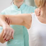 Dr. Odette Koch treating shoulder of female patient